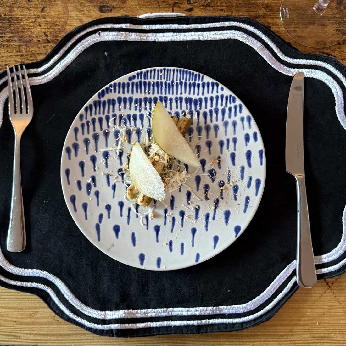 Braised leeks topped with shaved cheese, toasted nuts and thin pear slices